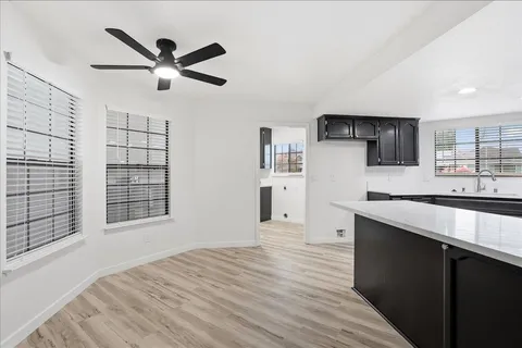 a view of a kitchen with a sink and dishwasher with wooden floor