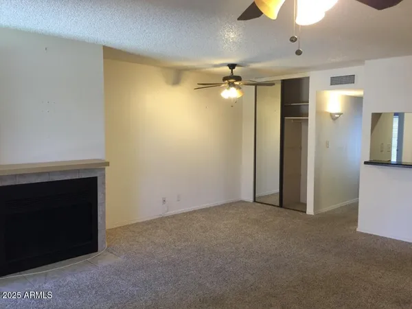 a view of empty room with a fireplace and fan