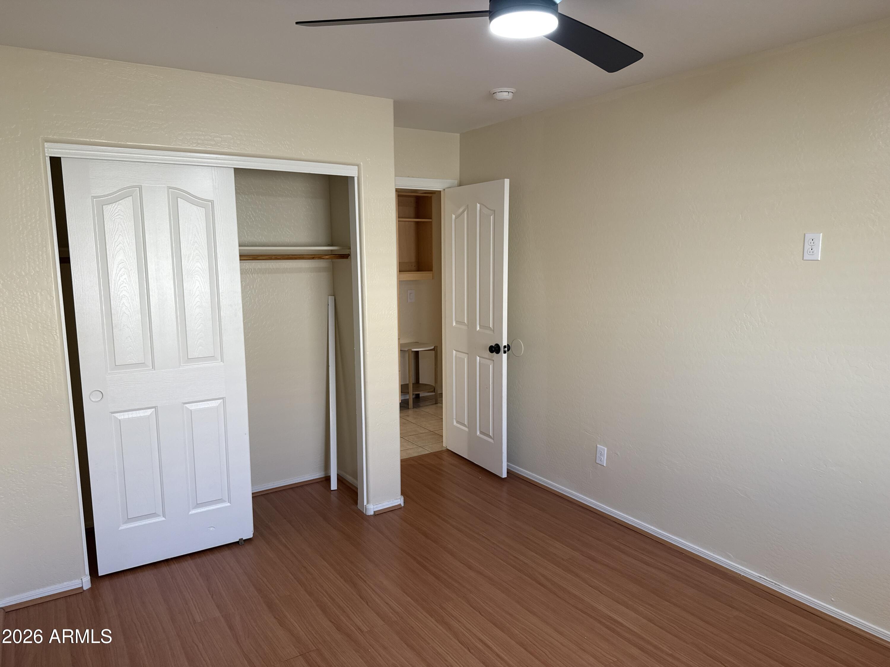 9630 West Reno View Drive Peoria, AZ 85345 - Photo 15 of 21 an empty room with wooden floor a ceiling fan