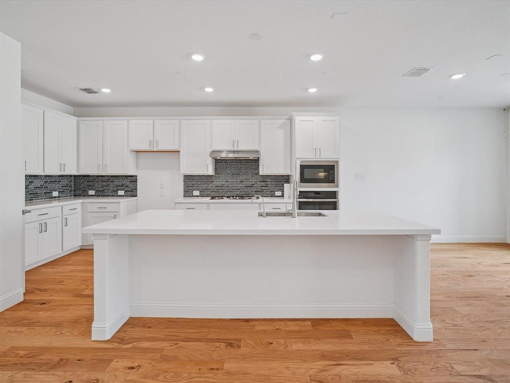 321 Fulton Street Oak Point, TX 75068 - Photo 11 of 36 a kitchen with stainless steel appliances granite countertop a stove a sink and white cabinets