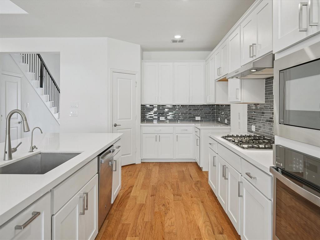 321 Fulton Street Oak Point, TX 75068 - Photo 15 of 36 a kitchen with stainless steel appliances granite countertop a sink stove and cabinets