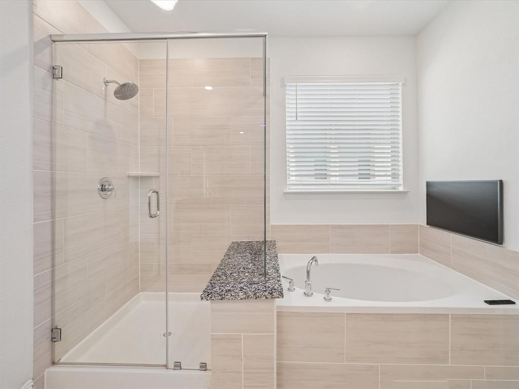 321 Fulton Street Oak Point, TX 75068 - Photo 18 of 36 a bathroom with a granite countertop bathtub shower and a sink