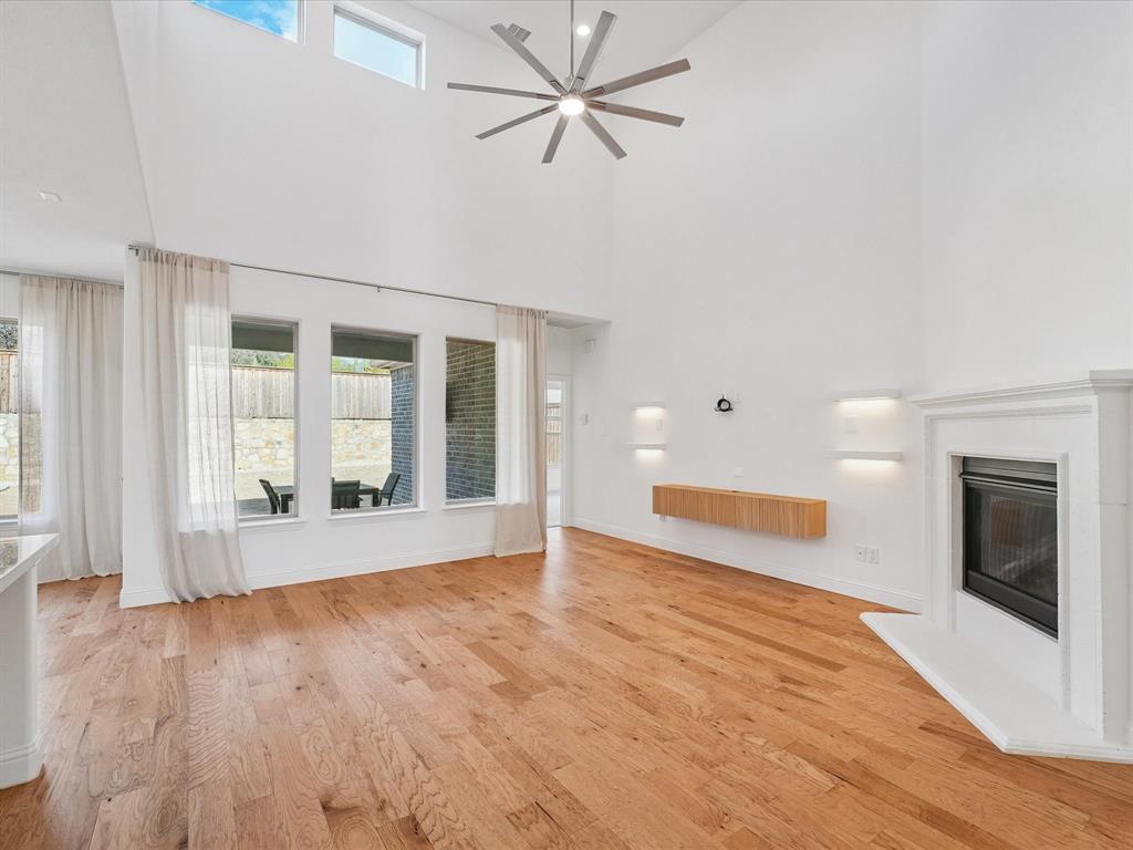 321 Fulton Street Oak Point, TX 75068 - Photo 8 of 36 an empty room with wooden floor and a fireplace