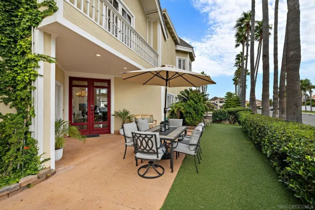 a view of a chair and table in the patio in front of a house