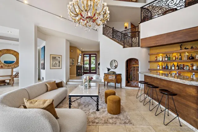 a living room with furniture a chandelier and a large window