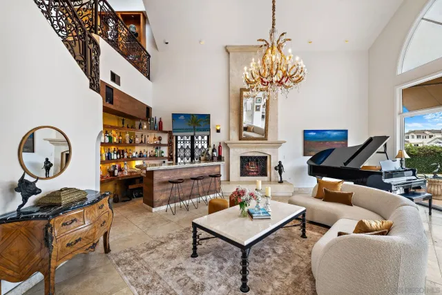 a living room with furniture a fireplace and a chandelier