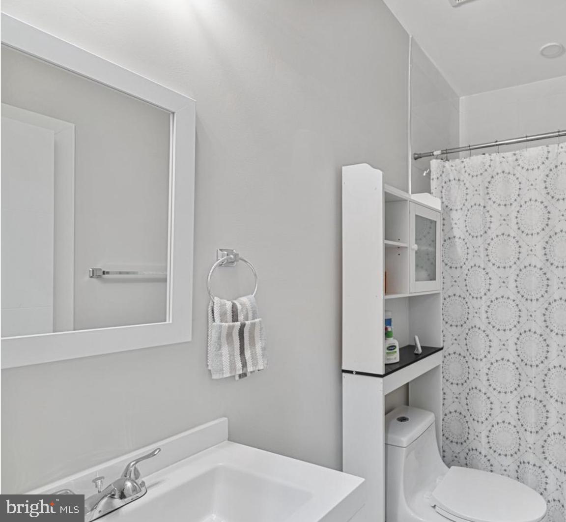820 18th Street Northeast, Unit 102 Washington, DC 20002 - Photo 15 of 17 a bathroom with a toilet sink and mirror