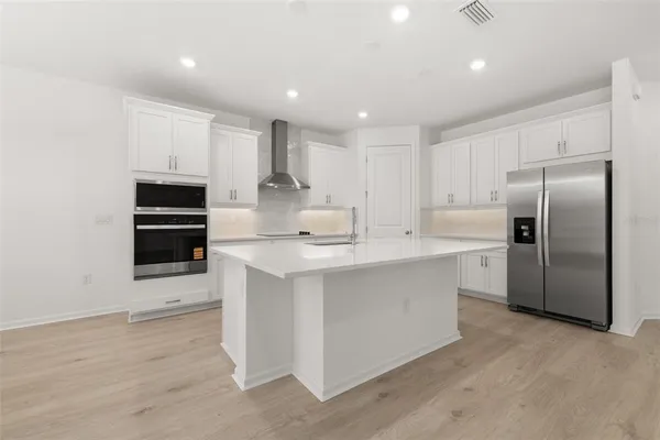 a kitchen with kitchen island a sink stainless steel appliances and cabinets