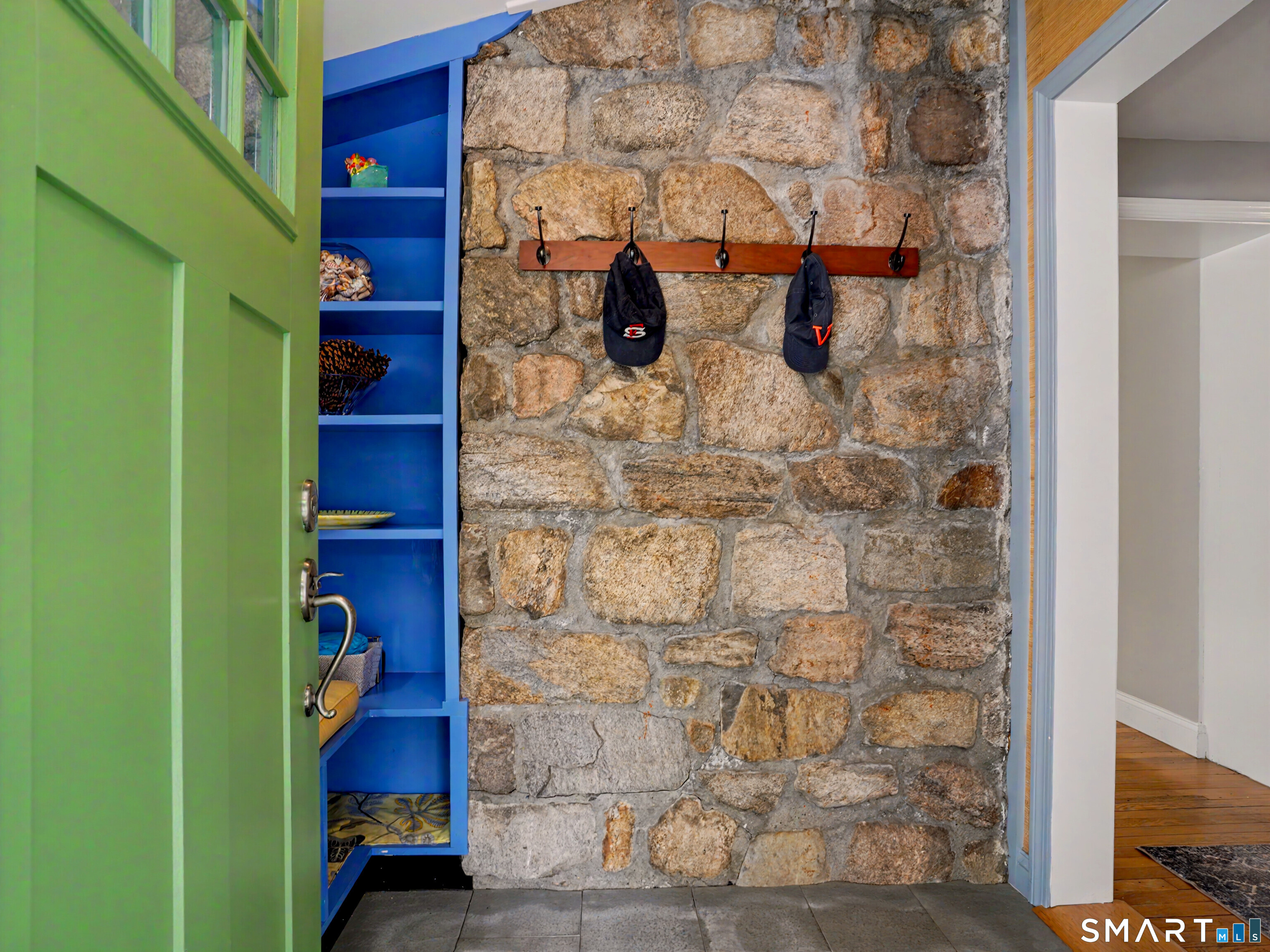 105 Ivy Hill Road Ridgefield, CT 06877 - Photo 5 of 39 The foyer features exposed stone, a bench with storage and a bluestone floor.