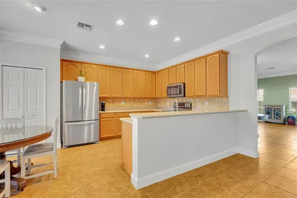 a view of kitchen with stainless steel appliances granite countertop a refrigerator and cabinets