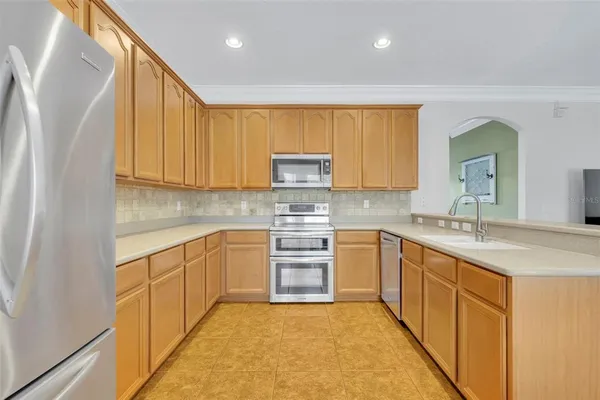 a kitchen with granite countertop a refrigerator stove top oven a sink and dishwasher