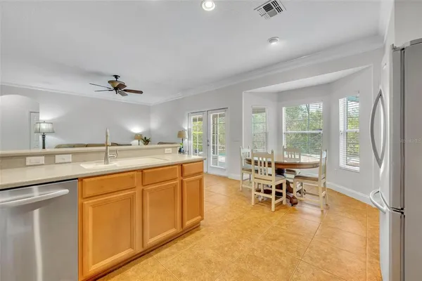 a kitchen with stainless steel appliances a refrigerator a stove a dining table and chairs