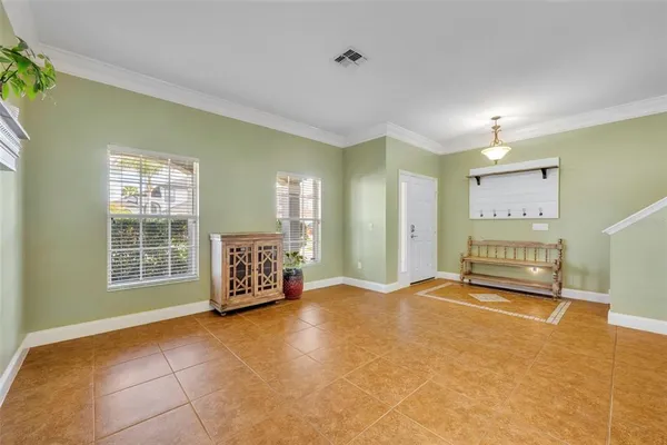 a view of a livingroom with furniture a rug a chandelier and kitchen view