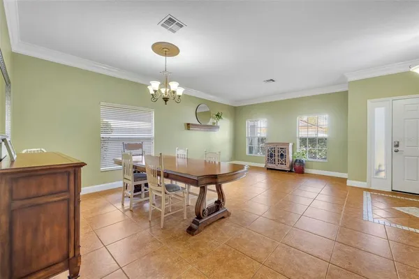 a dining room with furniture a chandelier and wooden floor