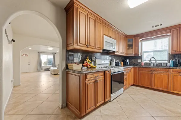 a kitchen with stainless steel appliances granite countertop a refrigerator and a stove