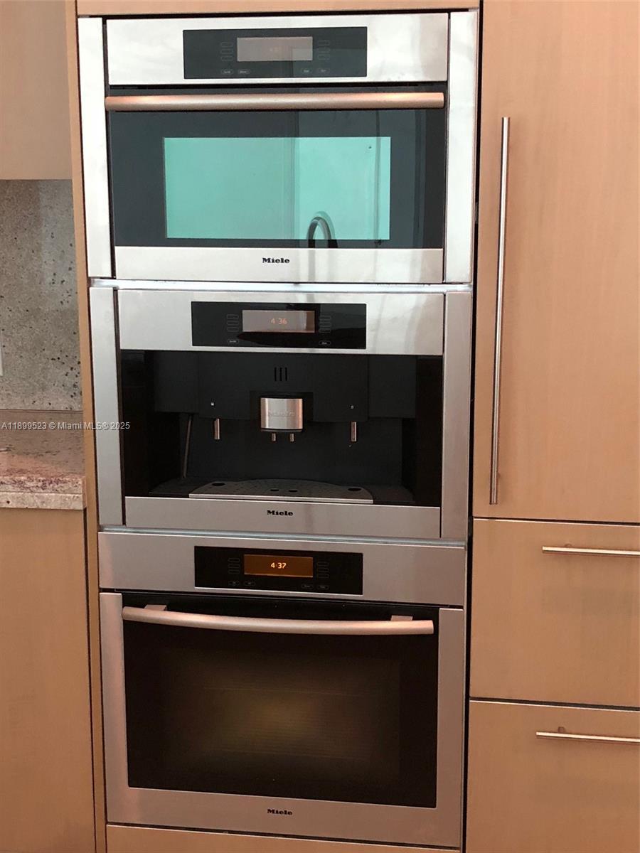 900 Brickell Key Boulevard, Unit 2205 Miami, FL 33131 - Photo 17 of 50 a stove top oven sitting inside of a kitchen