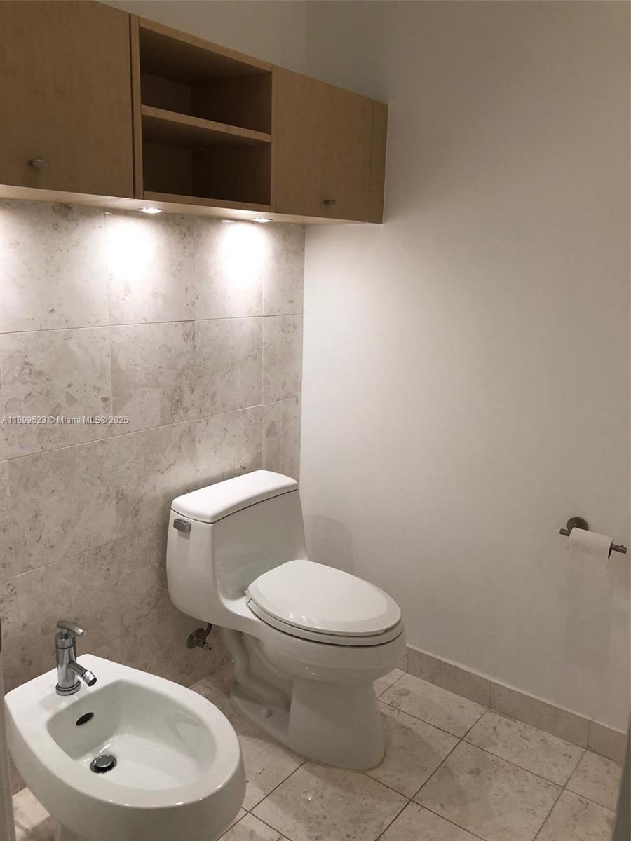 900 Brickell Key Boulevard, Unit 2205 Miami, FL 33131 - Photo 31 of 50 a white toilet sitting next to a bathroom sink
