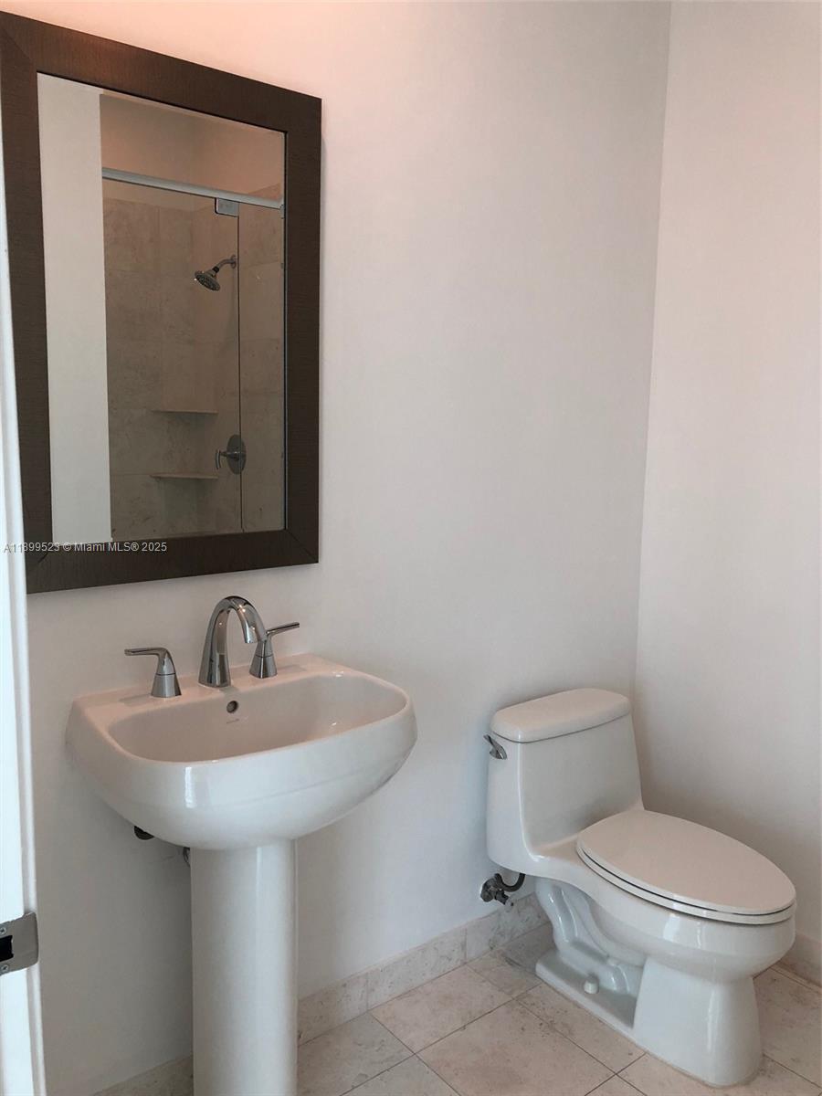 900 Brickell Key Boulevard, Unit 2205 Miami, FL 33131 - Photo 34 of 50 a bathroom with a toilet sink and mirror