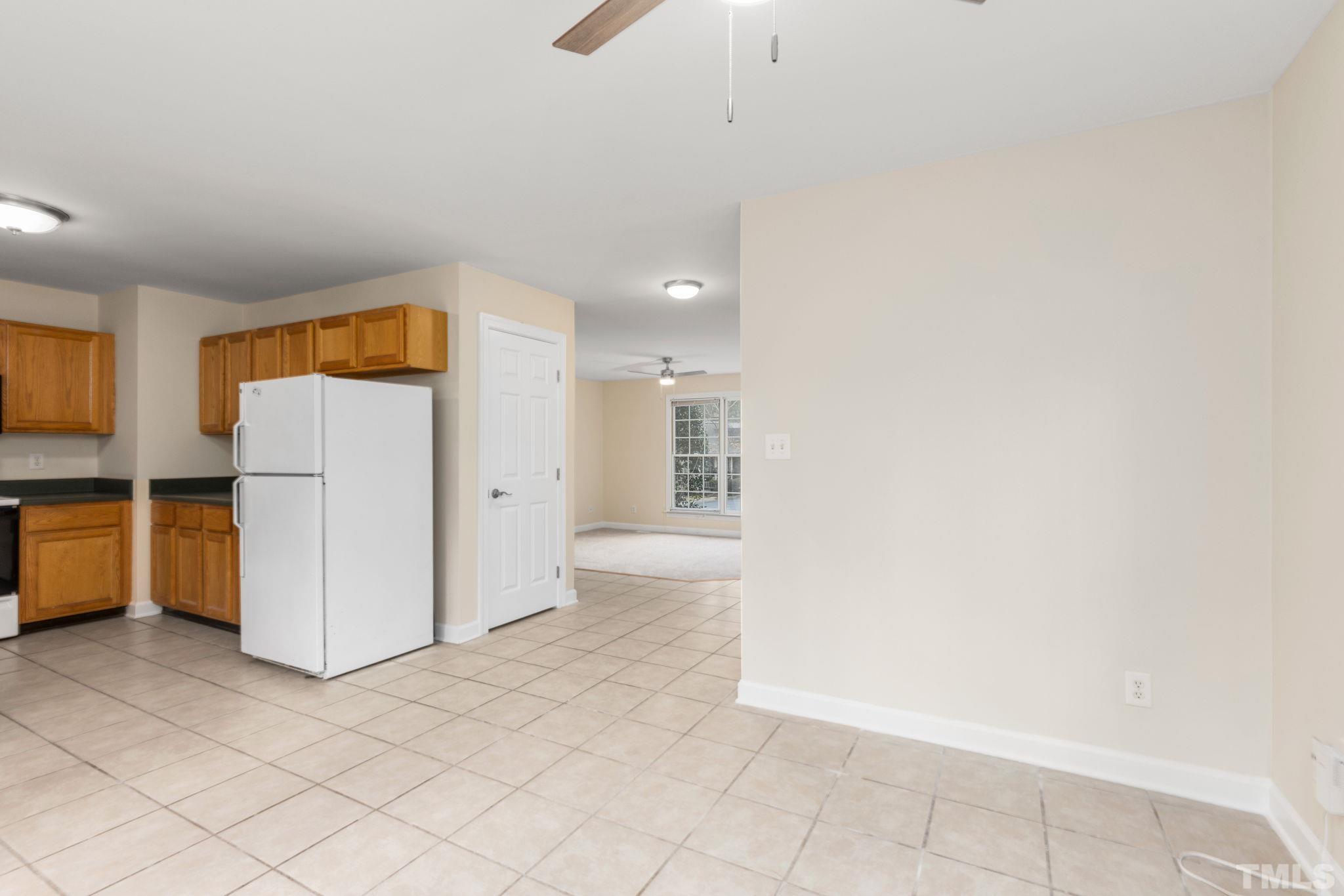 4313 Timberwood Drive Raleigh, NC 27612 - Photo 17 of 28 a view of a kitchen with refrigerator and white cabinets