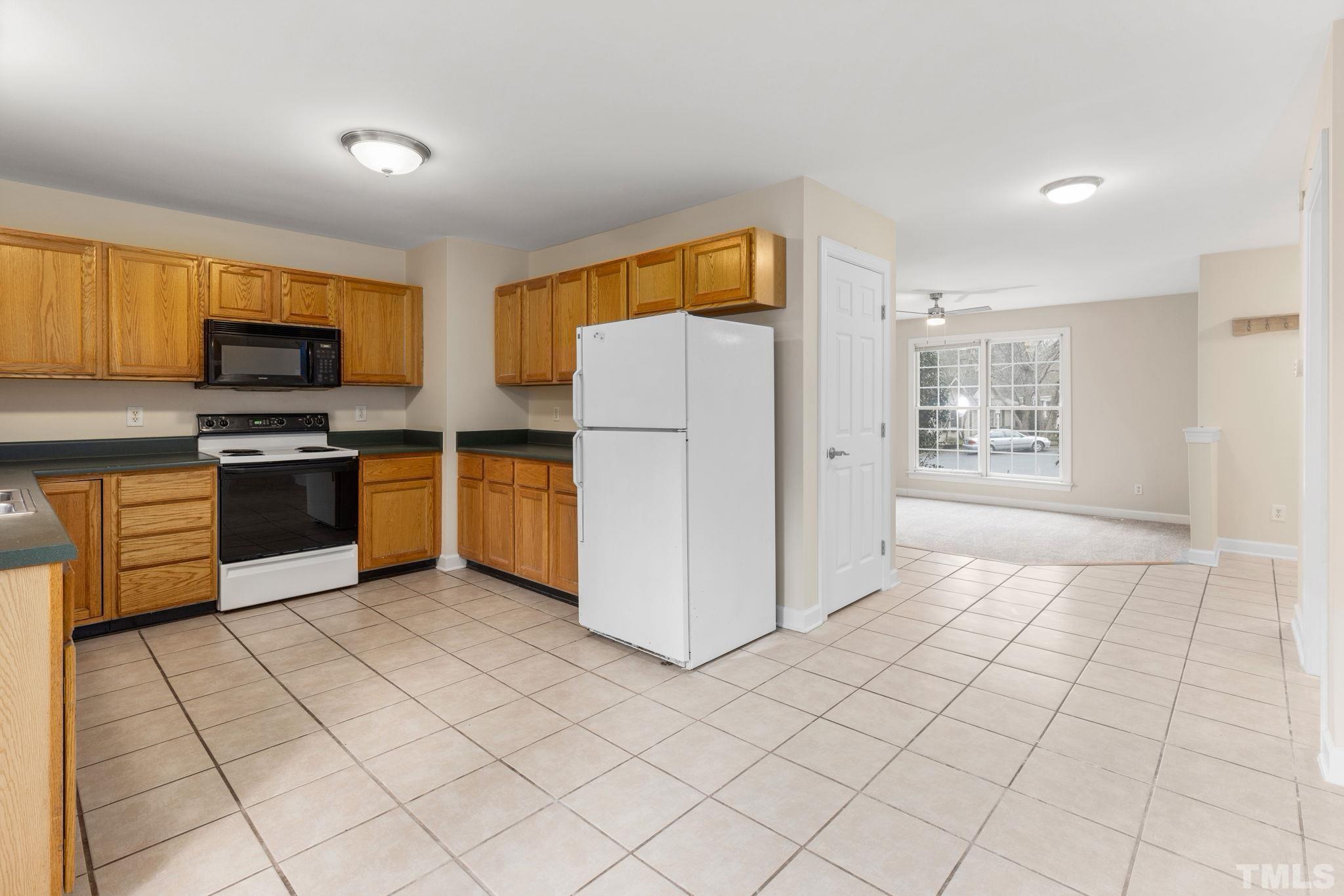 4313 Timberwood Drive Raleigh, NC 27612 - Photo 18 of 28 a kitchen with stainless steel appliances granite countertop a stove a sink and a refrigerator