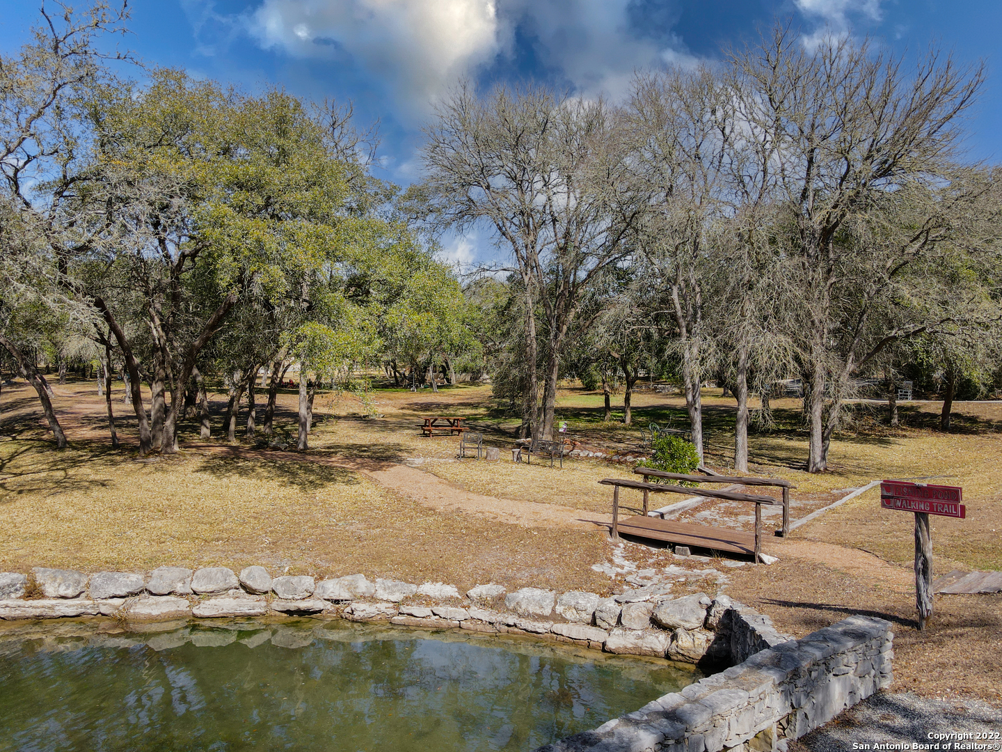 437 Private Rd 1706 Helotes, TX 78023 - Photo 2 of 8 a view of swimming pool with chairs and lake view