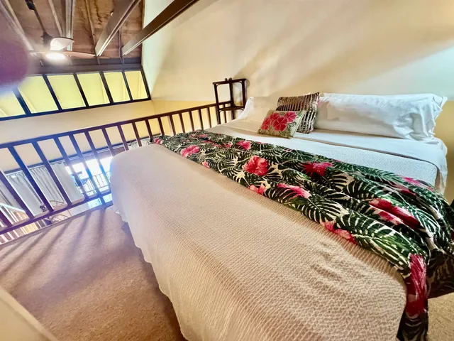 a bed with white sheets and pillows on it