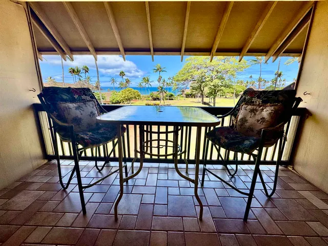 a view of an outdoor dining space with furniture and umbrella