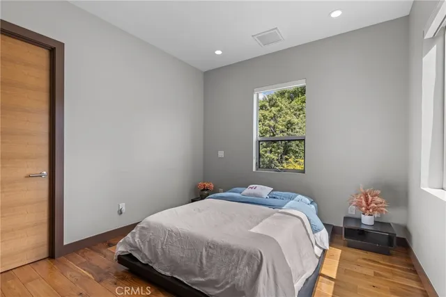 a bedroom with a bed and a flat tv screen on dresser