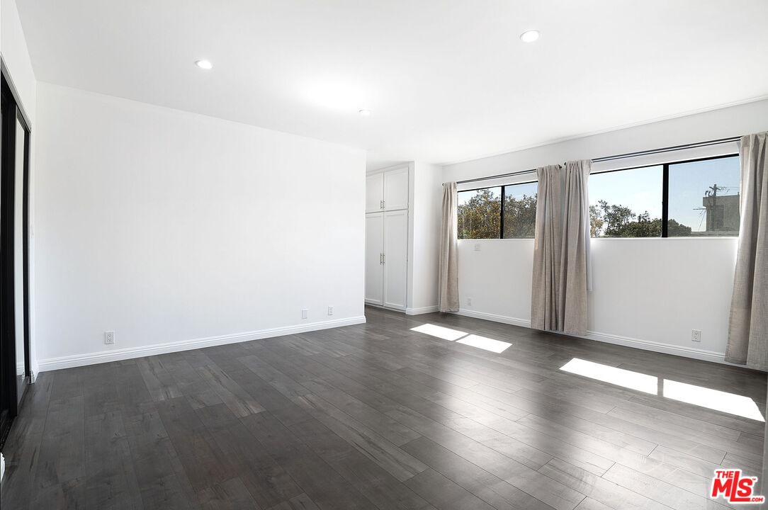 853 Le Doux Road, Unit 201 Los Angeles, CA 90035 - Photo 22 of 36 an empty room with wooden floor and windows