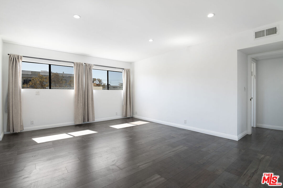 853 Le Doux Road, Unit 201 Los Angeles, CA 90035 - Photo 23 of 36 an empty room with wooden floor and windows
