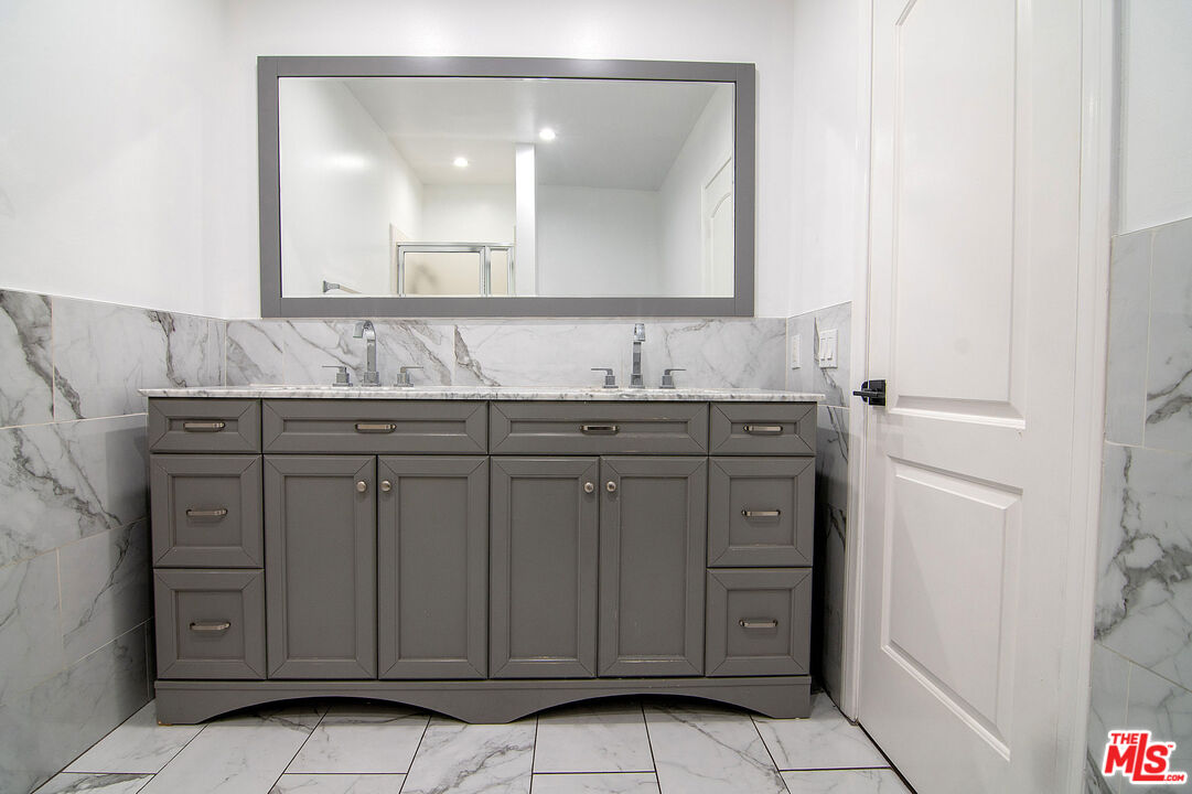 853 Le Doux Road, Unit 201 Los Angeles, CA 90035 - Photo 31 of 36 a bathroom with a granite countertop sink and mirror