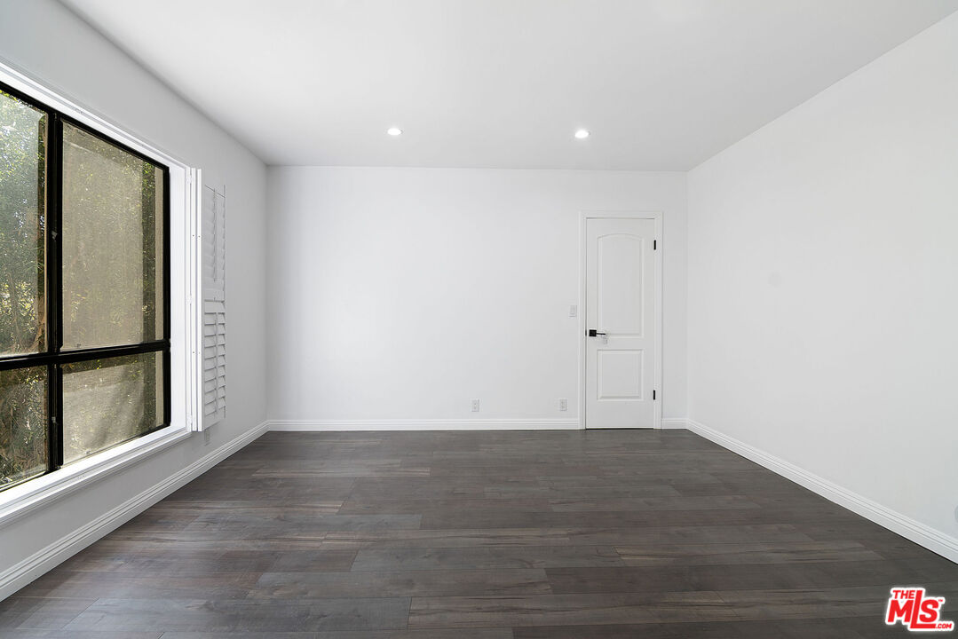 853 Le Doux Road, Unit 201 Los Angeles, CA 90035 - Photo 6 of 36 a view of an empty room with wooden floor and a window