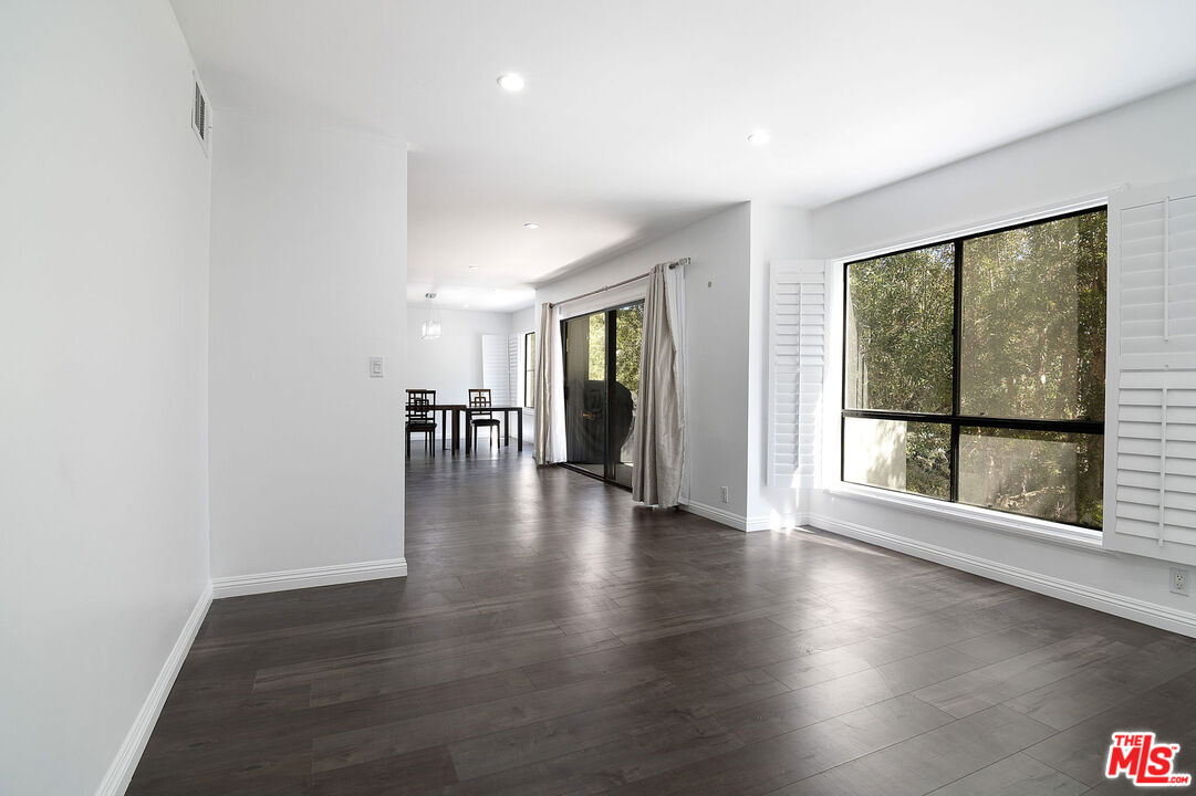 853 Le Doux Road, Unit 201 Los Angeles, CA 90035 - Photo 7 of 36 a view of an empty room with wooden floor and a window