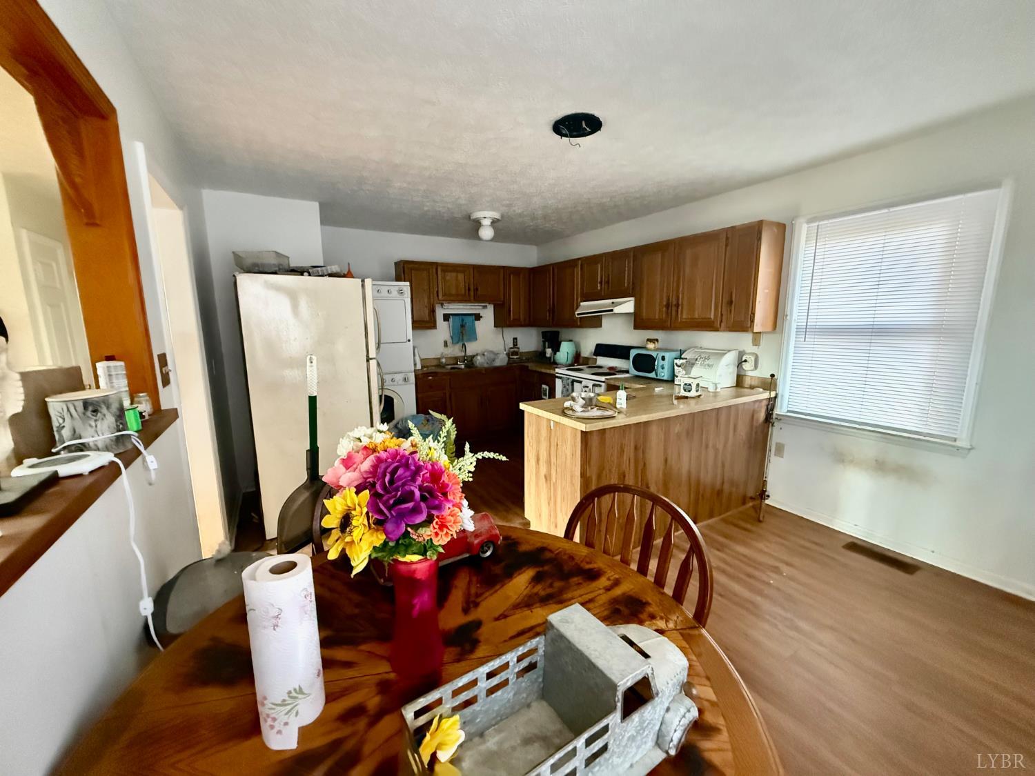 2600 Bethany Road Rustburg, VA 24588 - Photo 4 of 16 a kitchen with stainless steel appliances granite countertop a refrigerator a sink dishwasher a dining table and chairs with wooden floor