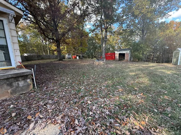 a backyard of a house with trees and outdoor seating