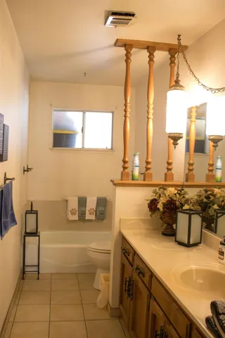 a bathroom with a sink a large mirror and a bathtub