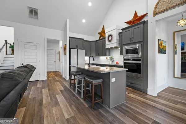 a kitchen with stainless steel appliances granite countertop a refrigerator a stove and a sink