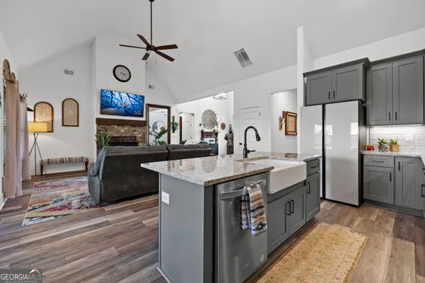 a kitchen with stainless steel appliances granite countertop a sink a stove and a refrigerator