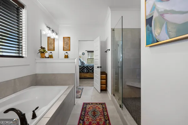 a bathroom with a tub a window and a shower