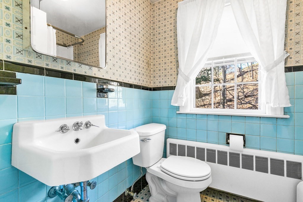 177 Varick Road Newton, MA 02468 - Photo 10 of 29 a white toilet sitting next to a bathroom sink