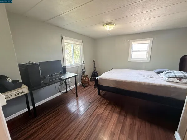 a bedroom with a bed and wooden floor