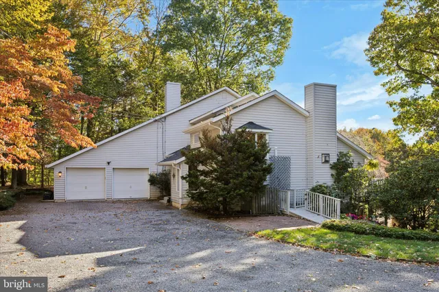 a view of a house with a yard and large tree