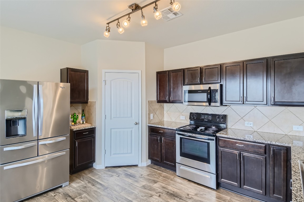 Ample counter space, tile backsplash and pantry closet.