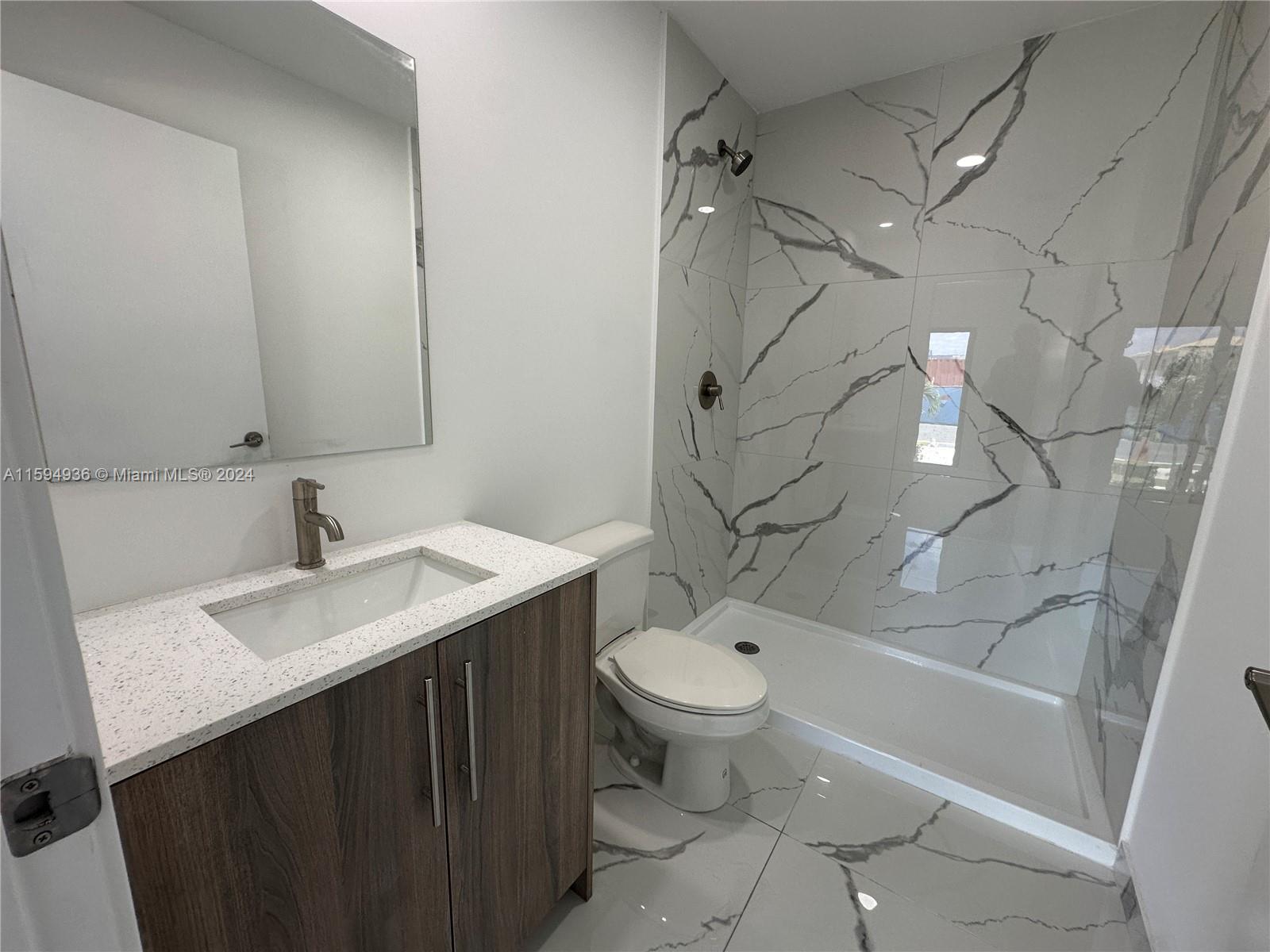 232 Northwest 13th Street, Unit 232 Homestead, FL 33030 - Photo 3 of 14 a bathroom with a sink toilet vanity and shower