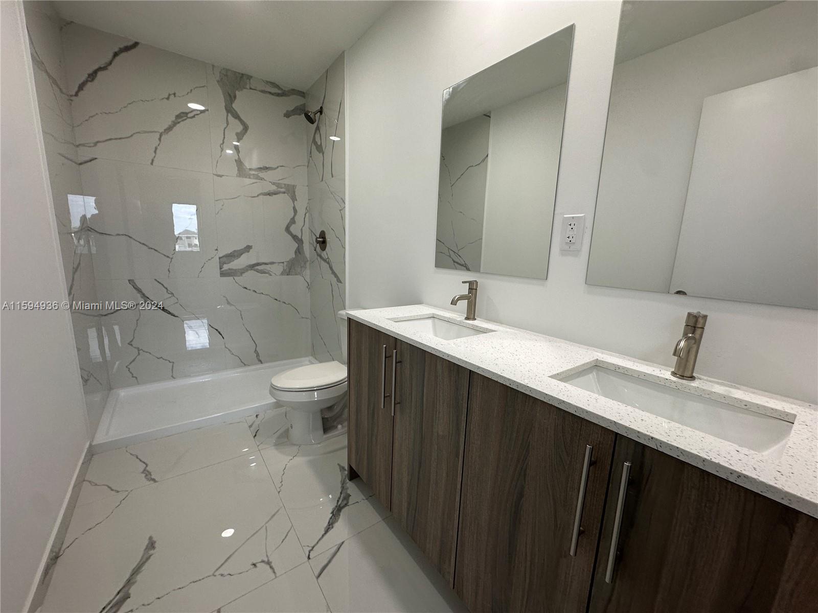 232 Northwest 13th Street, Unit 232 Homestead, FL 33030 - Photo 5 of 14 a spacious bathroom with a double vanity sink toilet and shower