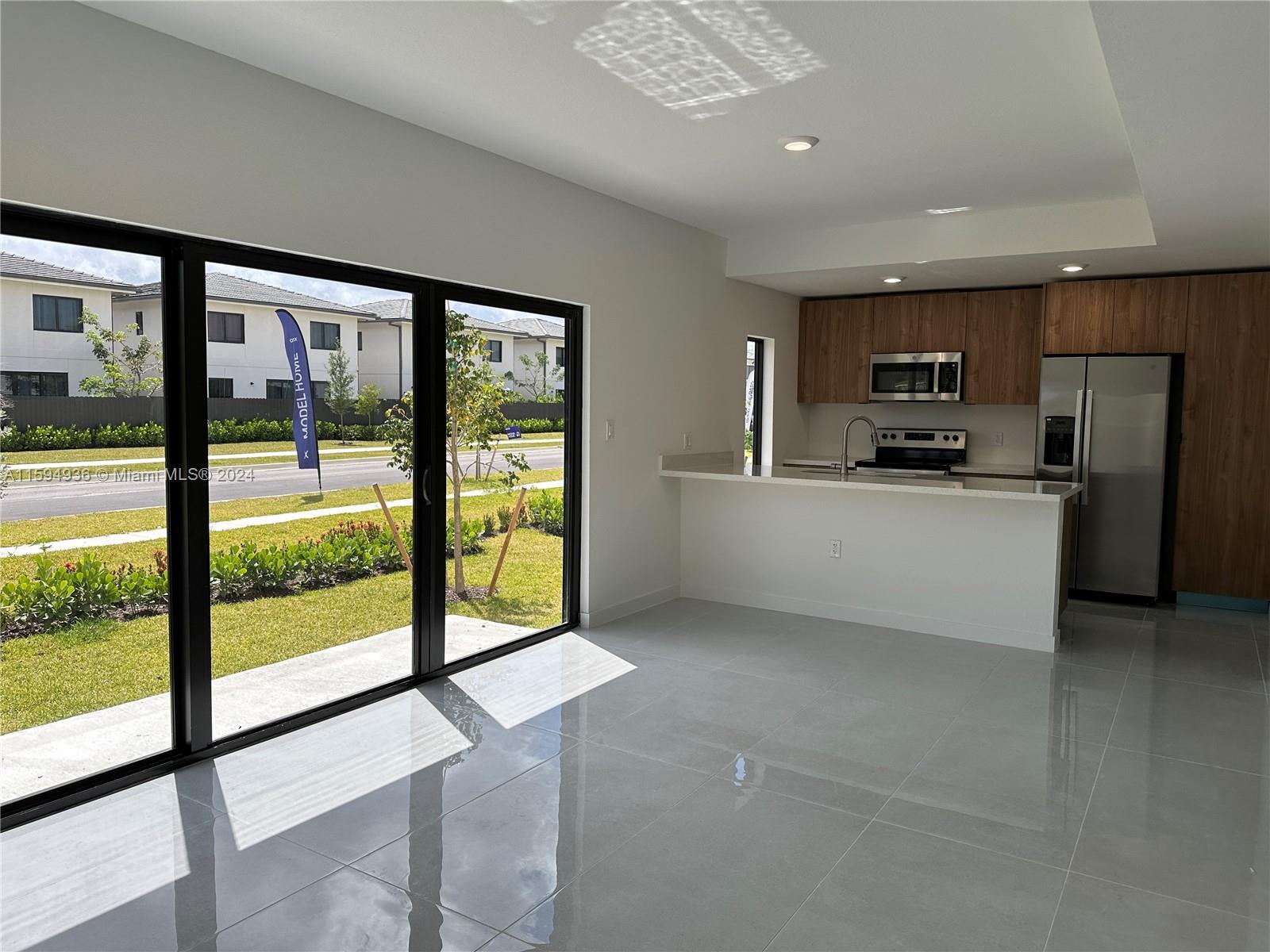 232 Northwest 13th Street, Unit 232 Homestead, FL 33030 - Photo 9 of 14 a kitchen with stainless steel appliances a sink and a large window