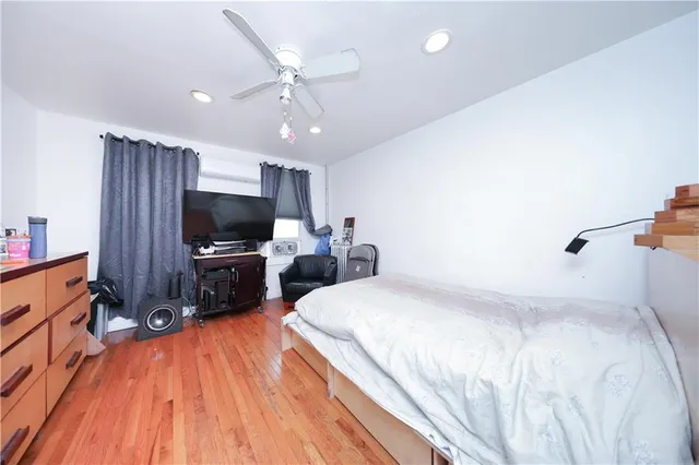 a bedroom with a bed and a flat tv screen on a dresser