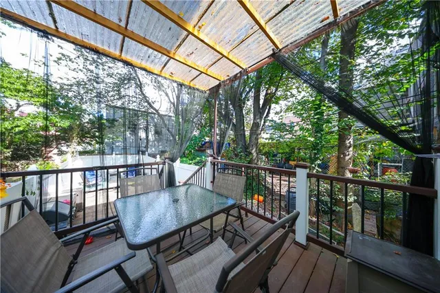 a view of a balcony with wooden floor and outdoor seating