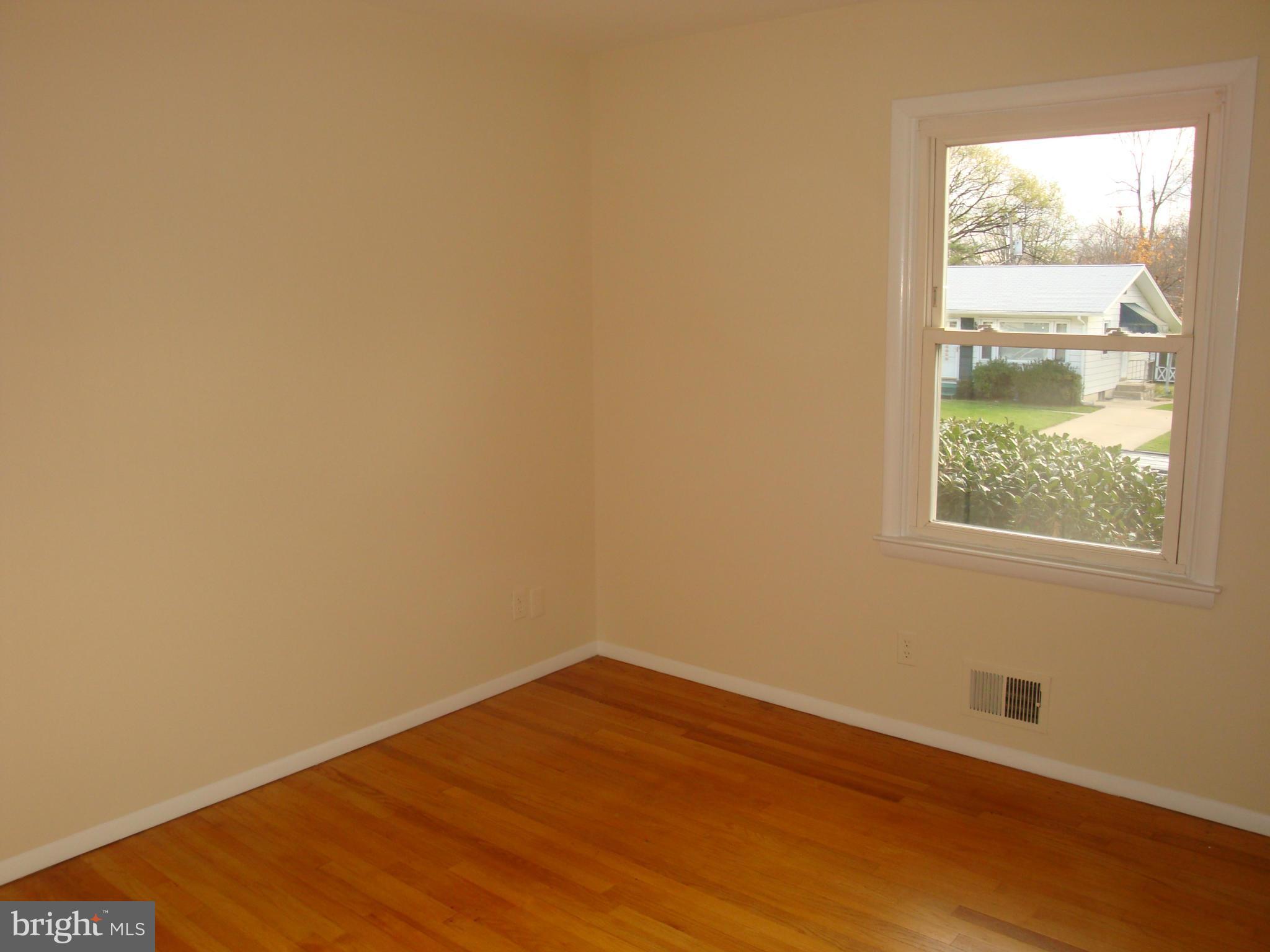 2414 Windsor Road Baltimore, MD 21234 - Photo 14 of 25 an empty room with wooden floor and windows