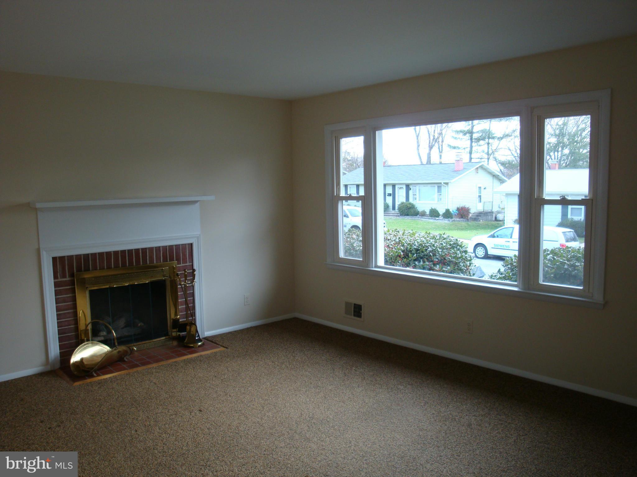 2414 Windsor Road Baltimore, MD 21234 - Photo 8 of 25 wooden floor fireplace and windows in an empty room